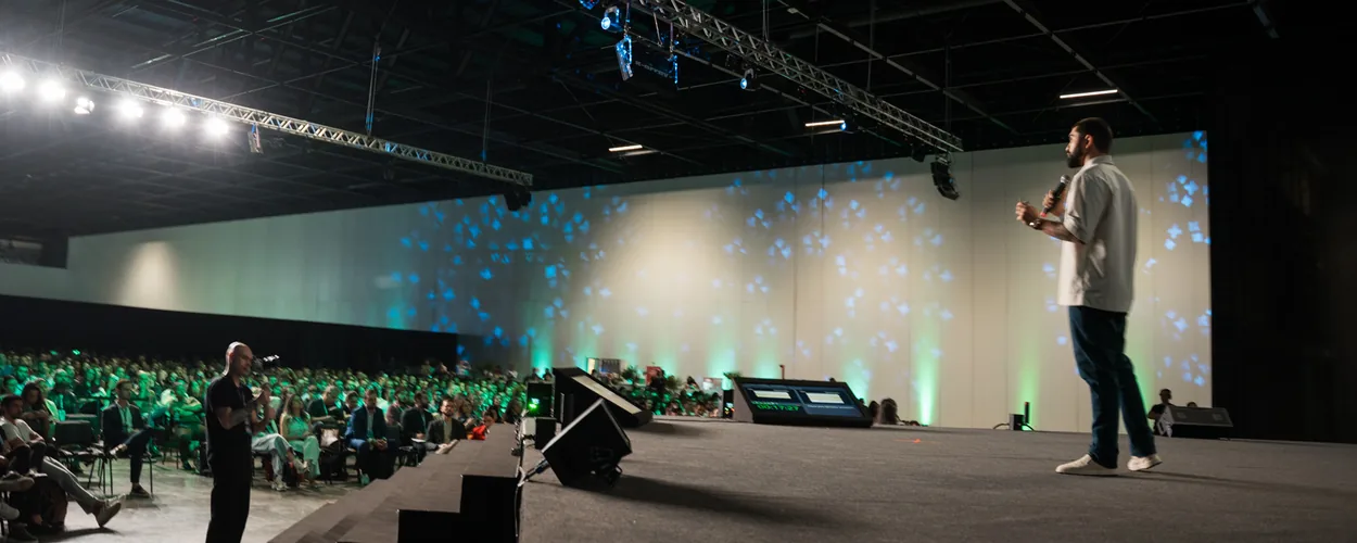 Gabriel Sobral no palco de evento com plateia